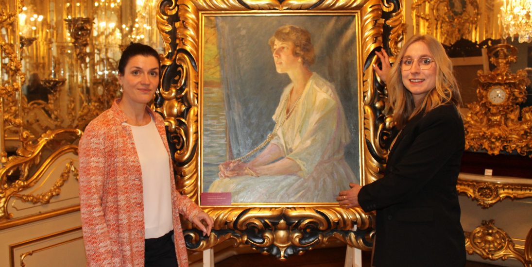 Geschäftsführerin Ina Klemm (l.) und Lara Klewin mit einem Gemälde, das die Fürstin Eleonore von Schönburg-Waldenburg zeigt. Foto: Uwe Wolf